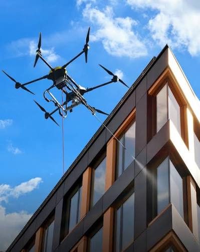 Drone cleaning the glazed upper elevation of a commercial building