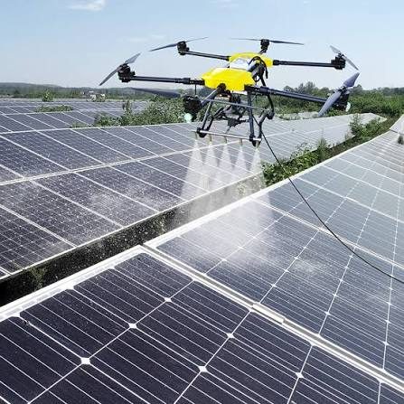 Drone applying a purified-water rinse across a commercial solar array